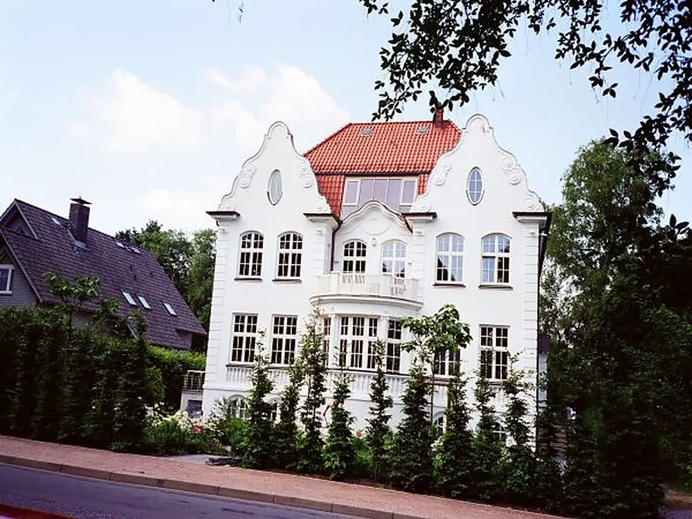 Weiße Villa mit Ziegeldach in gepflegter Grünanlage