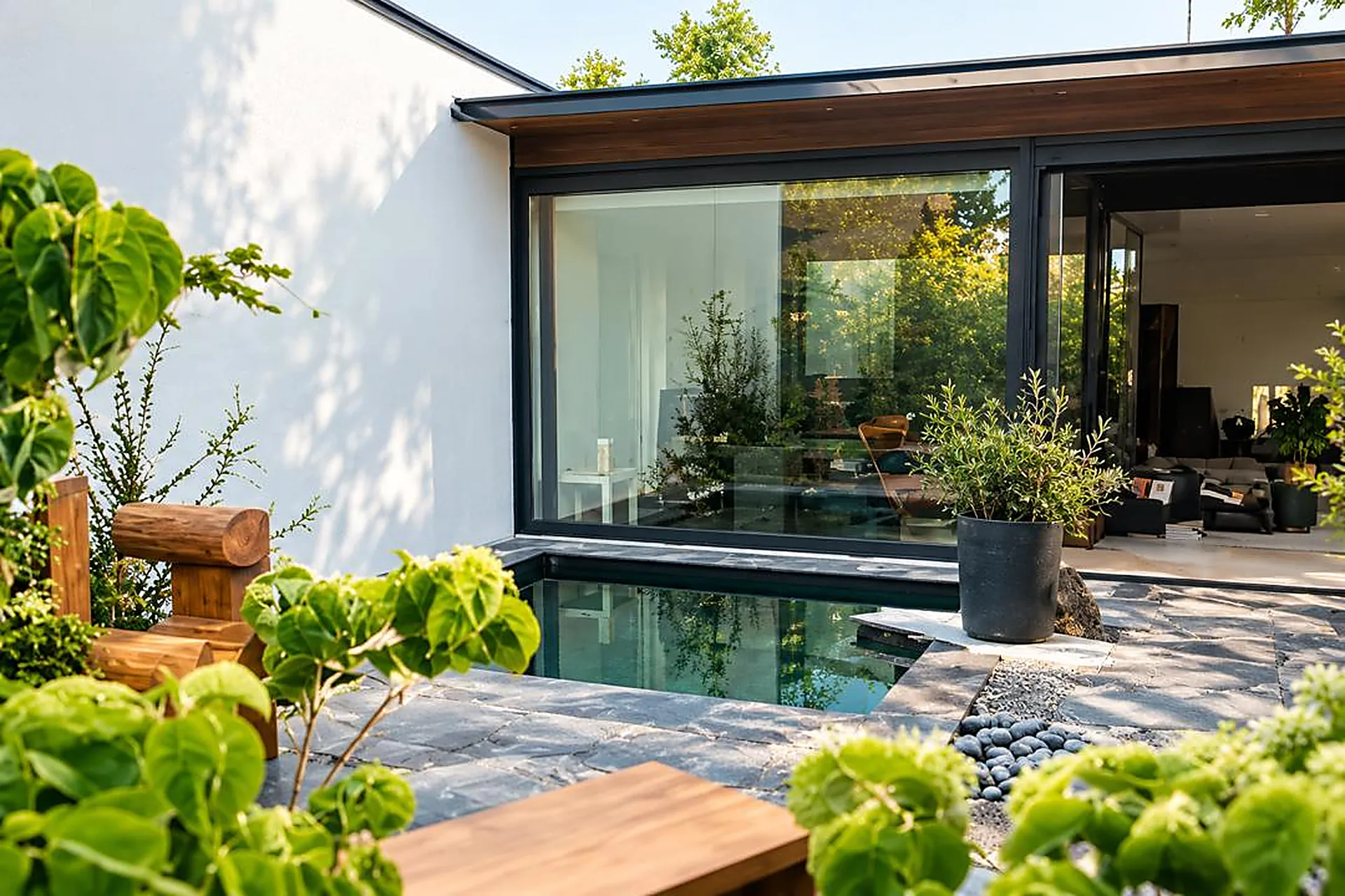 Moderne Gartenterrasse mit Wasserbecken, Natursteinplatten und Glasfronten